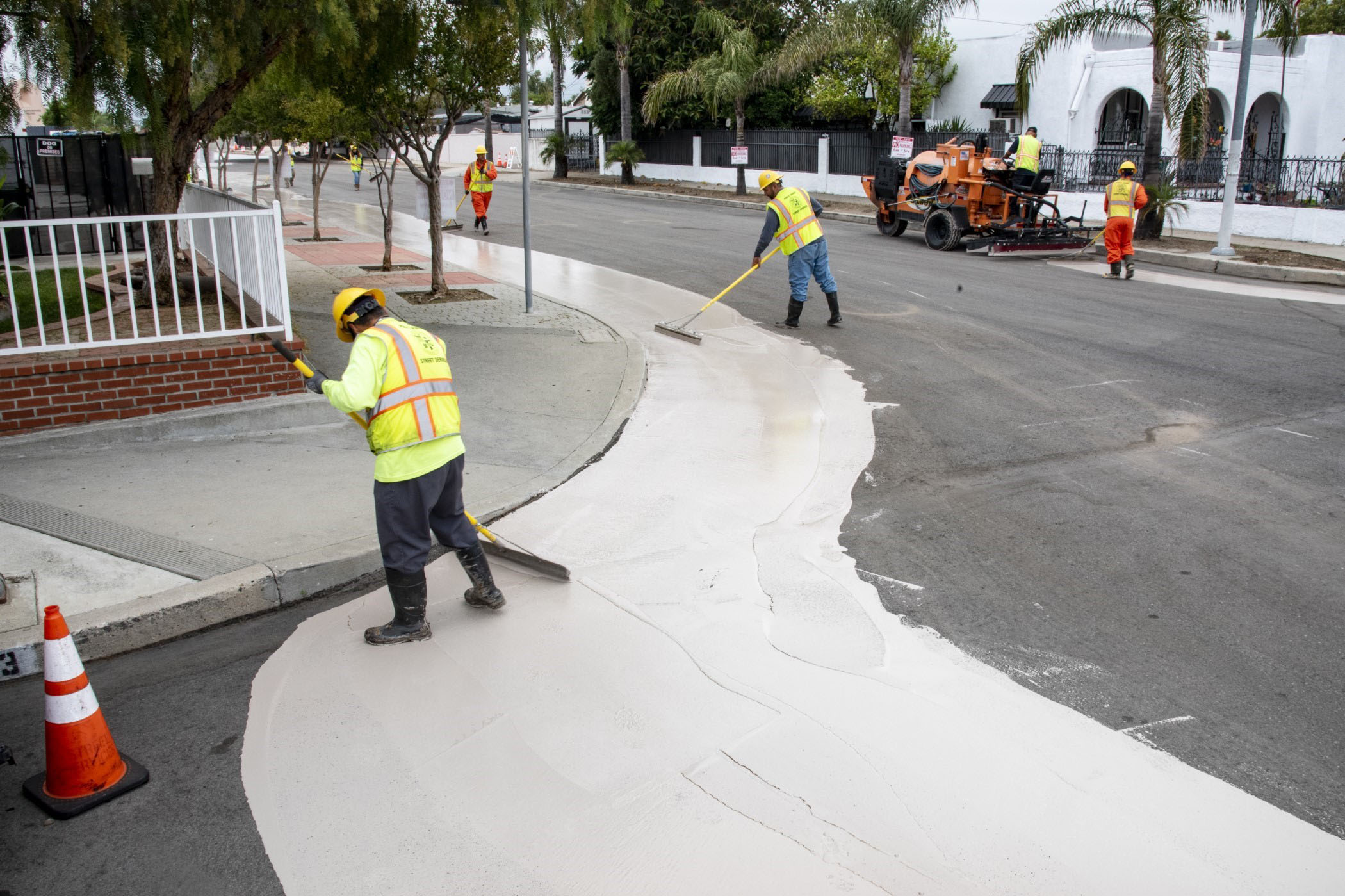 workers cover street with sealant