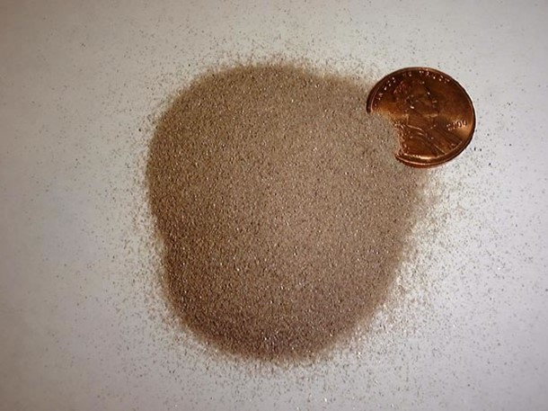 zircon sand with a U.S. penny for scale
