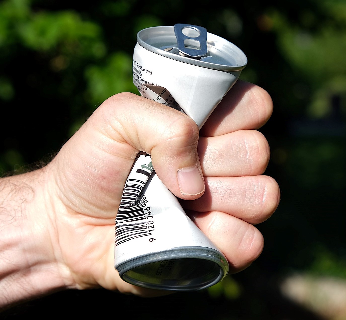 aluminum can being crushed by hand