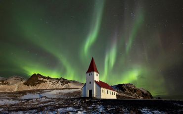 Northern lights (aurora borealis) over the Víkurkirkja church at Vík í Mýrdal, Iceland