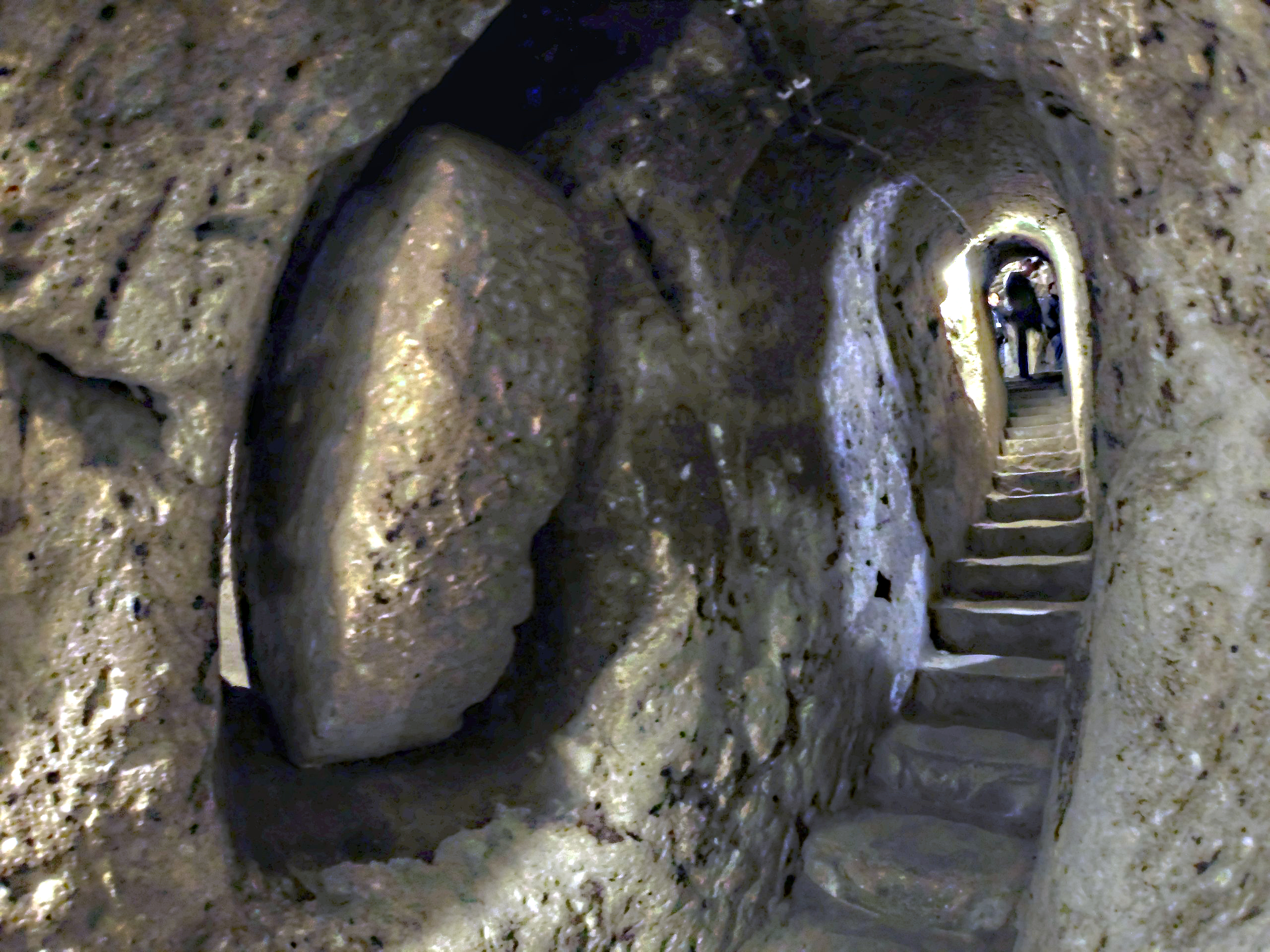 A stairway and one of the large stone doors that could be rolled into place to block intruders into the underground city of Derinkuyu.