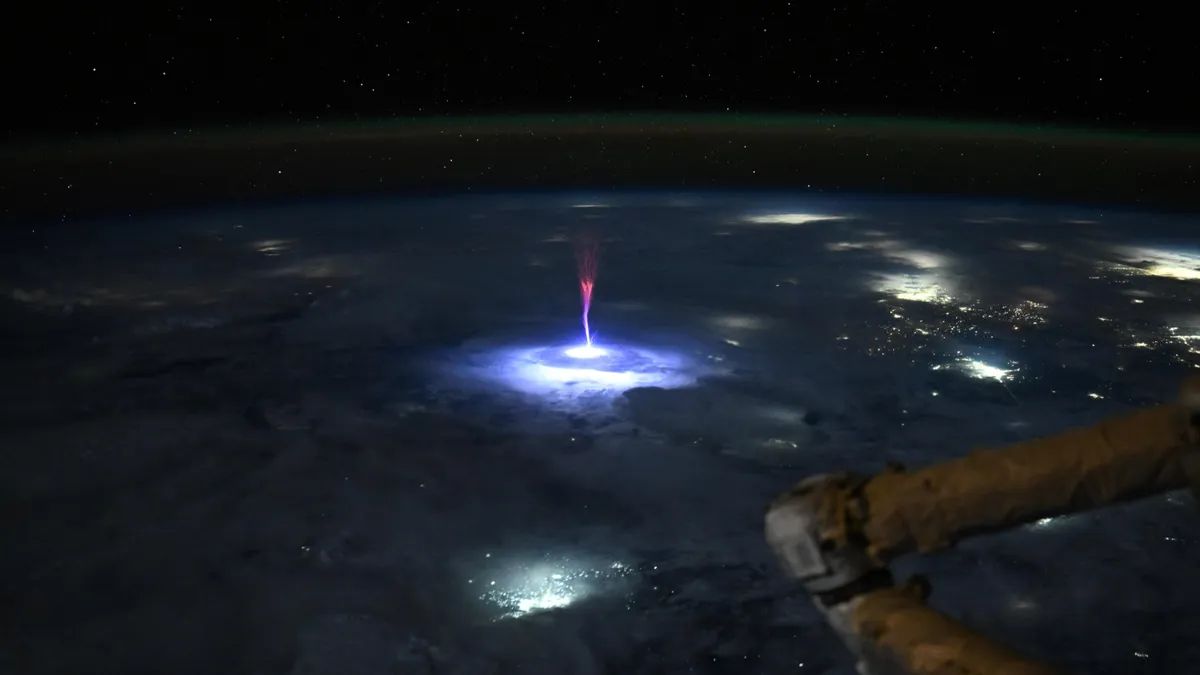 EarthDate 452-3 A red sprite flashes above a thunderstorm over Mexico and the southern U.S., captured by astronaut Nicole Ayers from the ISS.