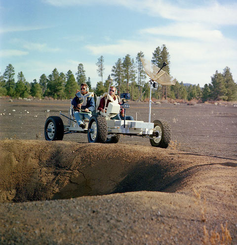 Apollo astronauts riding a mock-up of the lunar rover