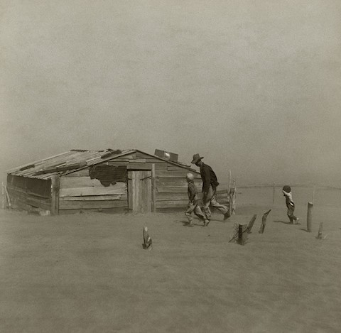 A farmer and his sons walk in the face of a dust storm