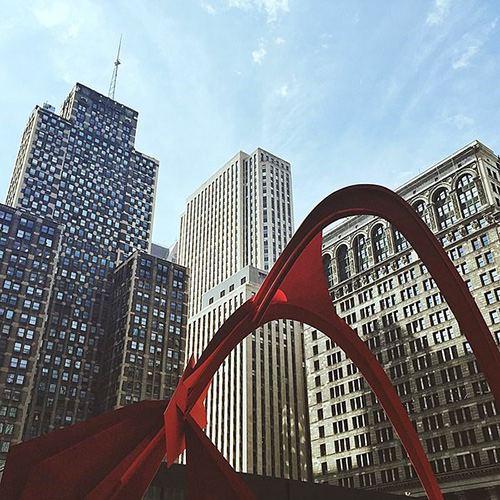 A steel sculpture surrounded by skyscrapers.